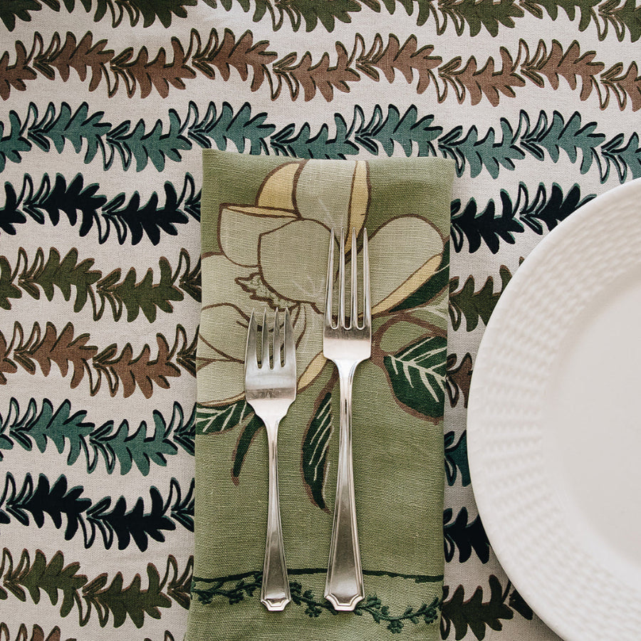 green napkin with floral design and utensils