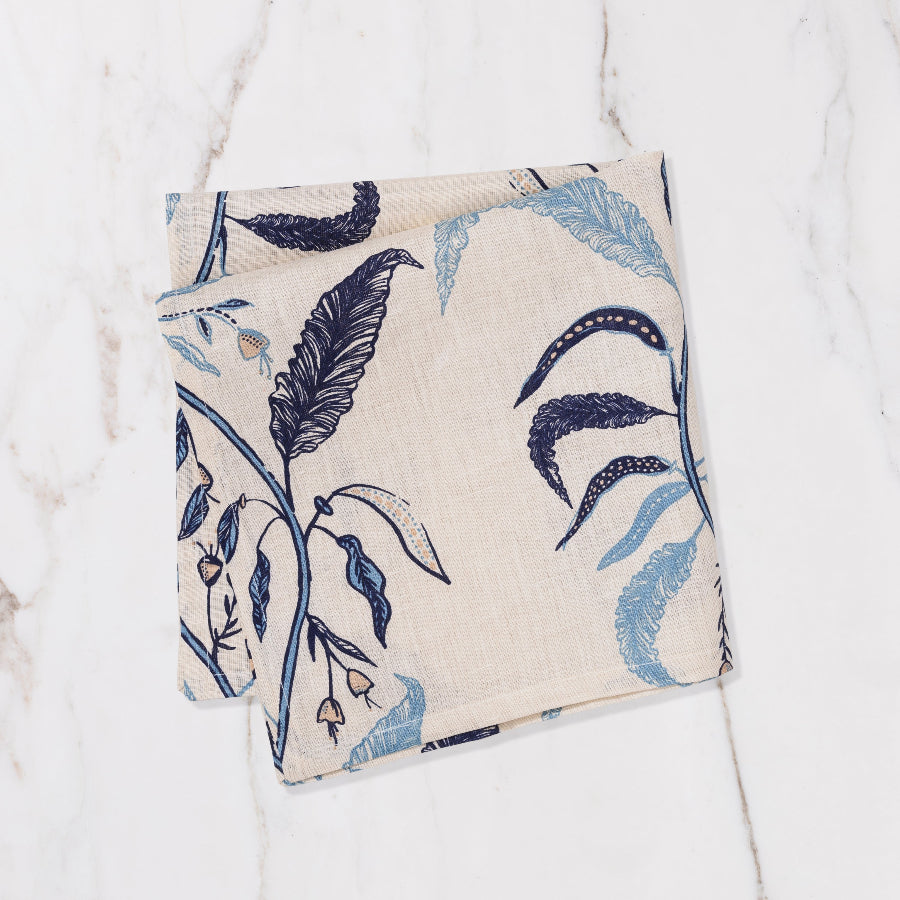 cream and blue napkin with floral and nature detailing