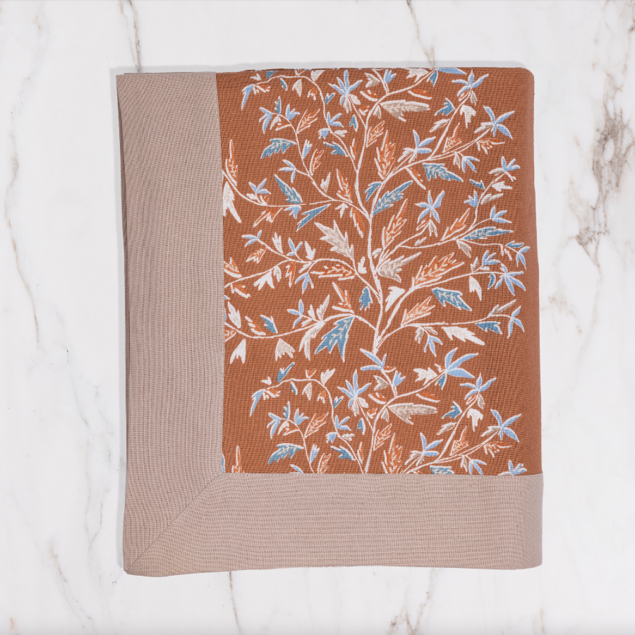orange tablecloth with brown lining and floral detailing