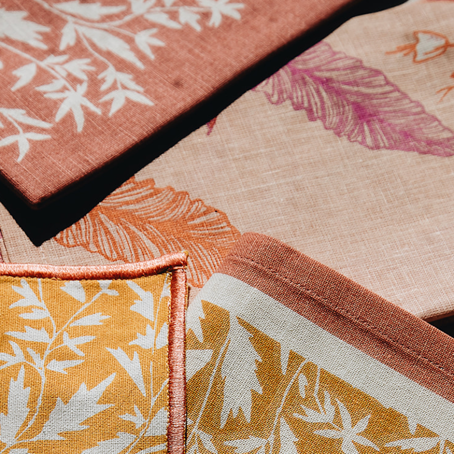 cream, yellow, orange, and pink tones napkin with floral and nature detailing