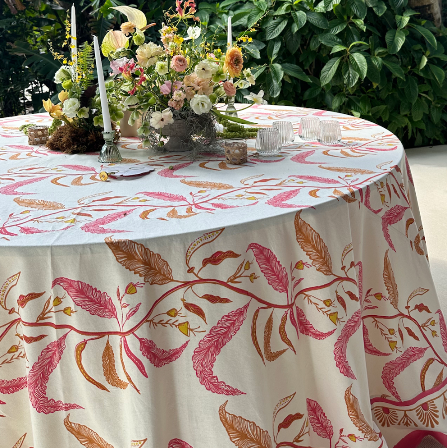 cream, pink, and orange tablecloth with floral design styled with floral arrangement